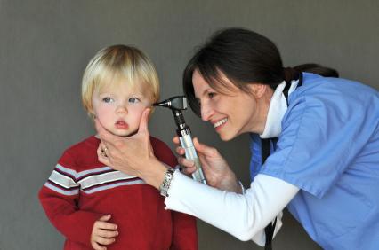 doctor or nurse examining toddler's ear