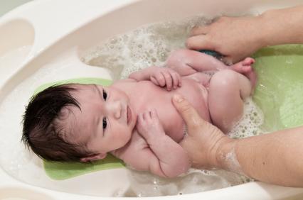 newborn baby getting a bath
