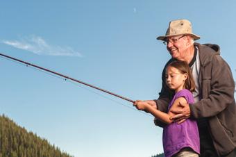 older man teaching young girl to fish