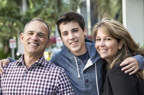 teen boy with arms around Mom and Dad